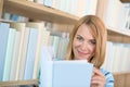 Student in library - happy woman study from book