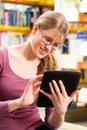 Student in library learning with tablet computer Royalty Free Stock Photo