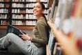 Student, library and smile for reading books in learning, education or knowledge at university. Happy woman smiling Royalty Free Stock Photo