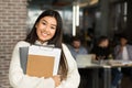 Student lifestyle. Asian girl posing in library interior Royalty Free Stock Photo