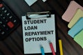 Student Loan Repayment Options write on a paperwork isolated on Wooden Table. Educational concept Royalty Free Stock Photo