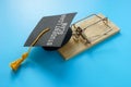 Student loan scam concept. Mouse trap and graduation hat. Royalty Free Stock Photo