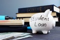Student loan written on a piggy bank and money.