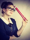 Woman holding big oversized pencil thinking about something Royalty Free Stock Photo