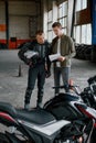 Student motorcyclist and instructor looking at test exam list