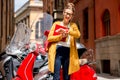 Student near red scooter in the city Royalty Free Stock Photo