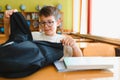 Student opening backpack at school desk getting ready for class Royalty Free Stock Photo