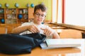Student opening backpack at school desk getting ready for class Royalty Free Stock Photo
