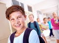 Student, portrait and boy with smile in hallway with education, study and backpack for back to school. Youth, young kid Royalty Free Stock Photo