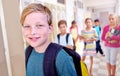 Student, portrait and kid with smile in hallway with education, study and backpack for back to school. Youth, young boy Royalty Free Stock Photo