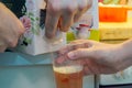 A Student Pouring Swedish Cardboard Wine Into a Plastic Mug