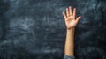 a student raising hand against a blackboard, representing participation in learning, suitable for an education concept Royalty Free Stock Photo