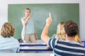 Student raising hand in classroom