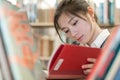 Student reading a book on bookshelf Royalty Free Stock Photo