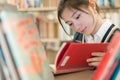 Student reading a book on bookshelf Royalty Free Stock Photo