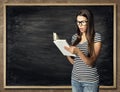 Student Reading Book over Blackboard Background, Amazed Woman Royalty Free Stock Photo