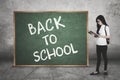 Student reads book near chalkboard Royalty Free Stock Photo