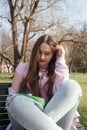 Student relaxing on a bench while reading a book outdoors on a sunny day Royalty Free Stock Photo
