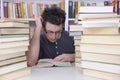 Student researching with books in a library Royalty Free Stock Photo