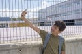 Student resting outside a school and playing with a mobile phone Royalty Free Stock Photo