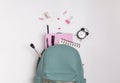 Student`s backpack with different stationery and study supplies on the white background Royalty Free Stock Photo