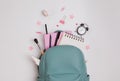 Student`s backpack with different stationery and study supplies on the white background Royalty Free Stock Photo