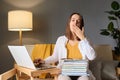 Student preparing for a test. Laptop in the study room. Sleepy young woman student working at home sitting Royalty Free Stock Photo