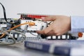 The student's hand is extended to the elements of the robotic training model. No face. Selective focus