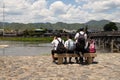 Student schoolchildren are sitting on a bench near Katsura river, Kyoto, Japan