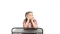 Student seems bored. Uninterested student isolated on white. Small girl student sitting at desk. Little student having