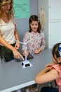 Student showing solar windmill to classmate in ecology classroom