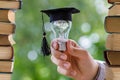 Student shows light bulb in the cap academic . Royalty Free Stock Photo