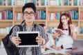 Student shows tablet in the library