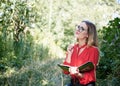 Student, sitting on the blanket in park, holding notebook and pencil, thinking. Close-up picture of young blond woman, wearing Royalty Free Stock Photo