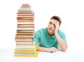 Student sitting at the desk with high books stack Royalty Free Stock Photo