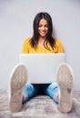 Student sitting on the floor and using laptop