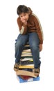 Student sitting on a pile of books