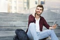 Student sitting on the steps listening to music outdoors Royalty Free Stock Photo