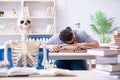 The student skeleton listening to lecture in classroom Royalty Free Stock Photo