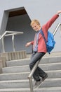 Student sliding down railing on stairway