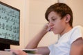 A student solves math problems on a computer. a teenage boy is studying online