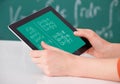 Student solving math's problem on digital tablet in classroom