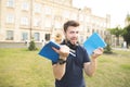 Student standing on the background of the university building with notebooks and books in his hands Royalty Free Stock Photo