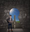 Student standing on a key hole door Royalty Free Stock Photo