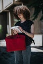 Student holding a red bag while reading notes outdoors Royalty Free Stock Photo