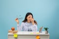 Student Struggles With Focus While Studying at a Desk Filled With Notes and an Apple in a Light Blue Room Royalty Free Stock Photo