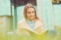 Student studying outside outdoors in campus. Closeup business woman smiling reading book, contract sitting on grass meadow in park Royalty Free Stock Photo