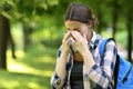 Student suffering allergy symptoms scratching eyes in a park Royalty Free Stock Photo