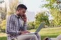 Young business man with laptop working in the park near office building Royalty Free Stock Photo