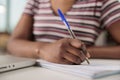 Student taking notes in notebook close up, studying online Royalty Free Stock Photo